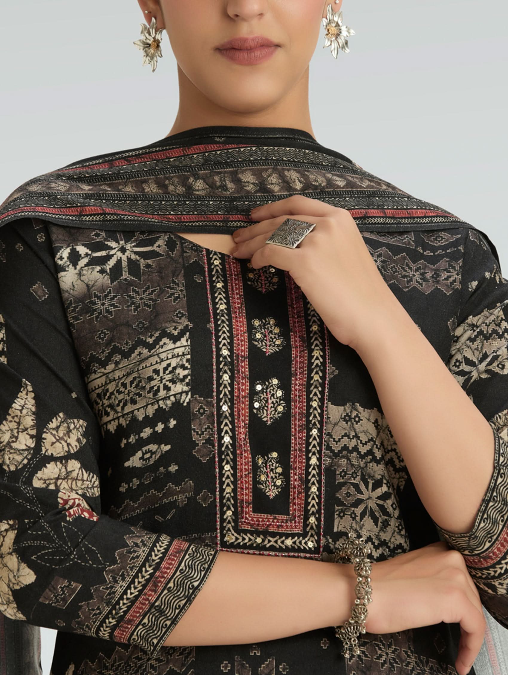 Black embroidered traditional outfit with intricate patterns on a plain background