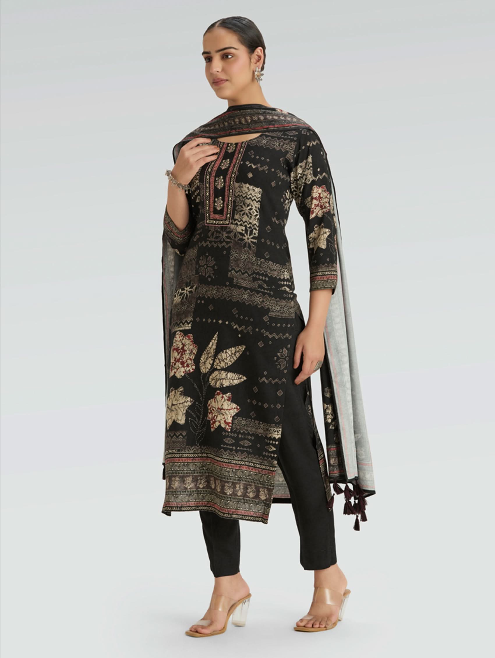 Woman wearing a black floral patterned suit with a white background