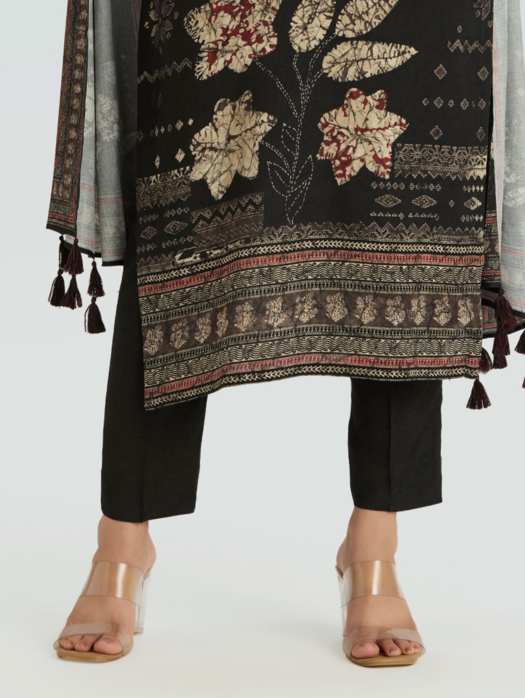 Traditional outfit with a patterned black shawl and black pants on a white background