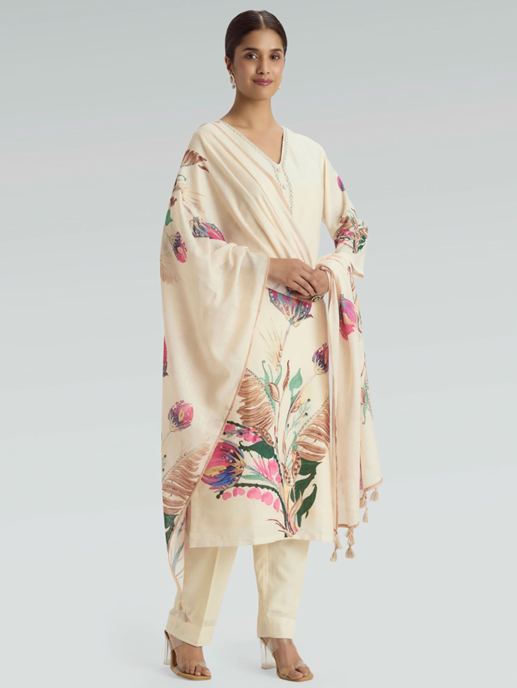 Woman wearing a cream kurta with floral dupatta on a light gray background