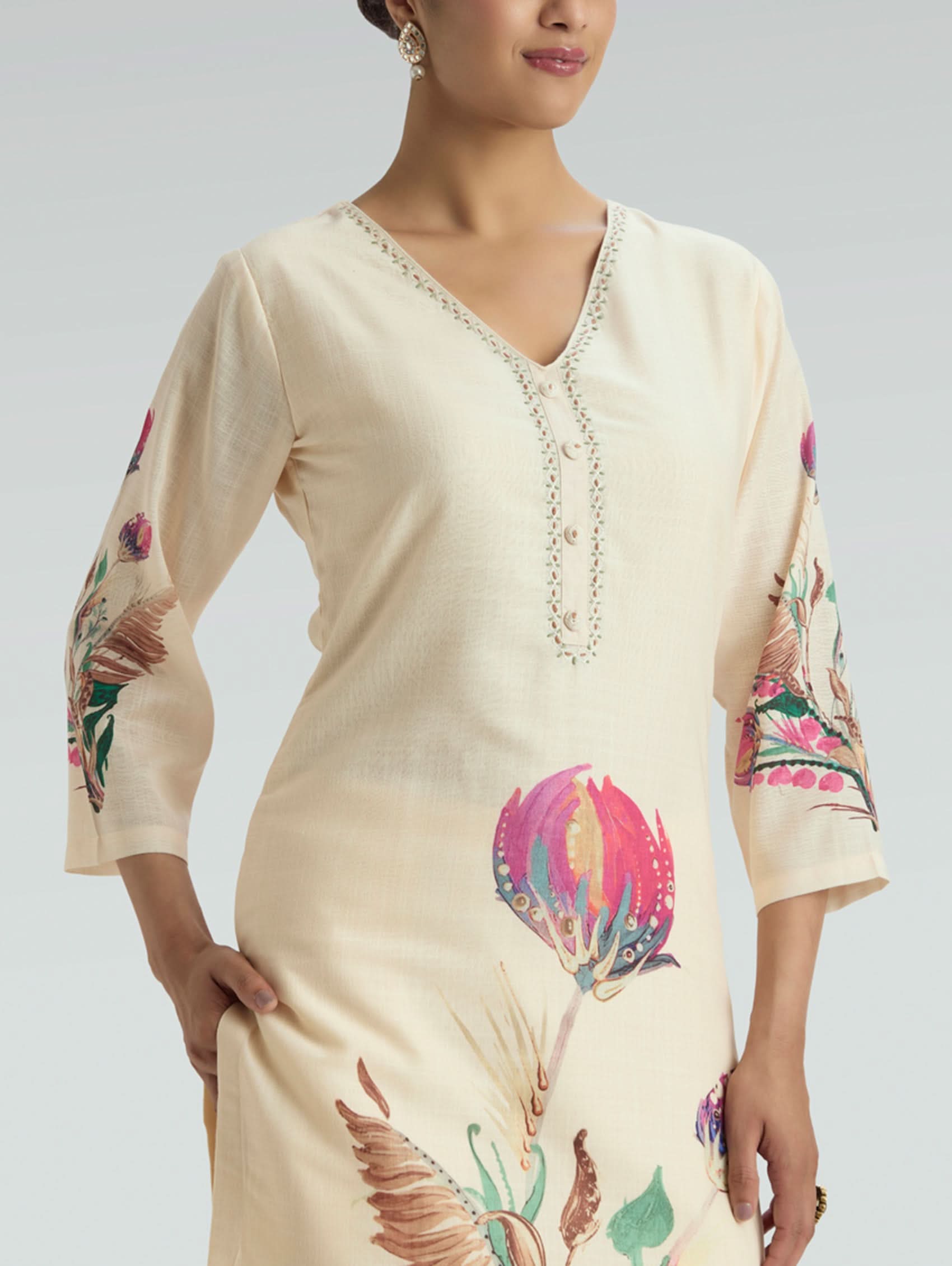 Beige dress with floral and bird patterns on sleeves and skirt, worn by a model.