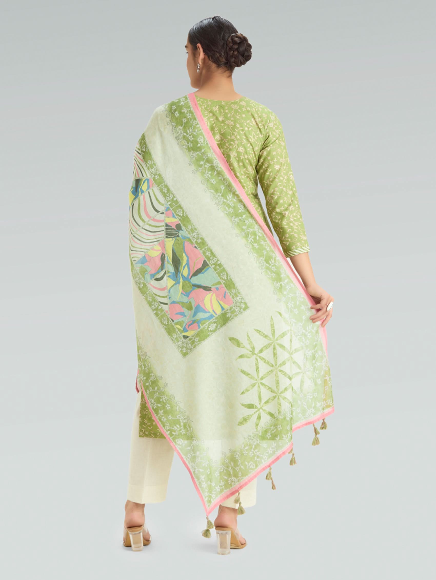 Woman wearing a green and white patterned dupatta on a gray background