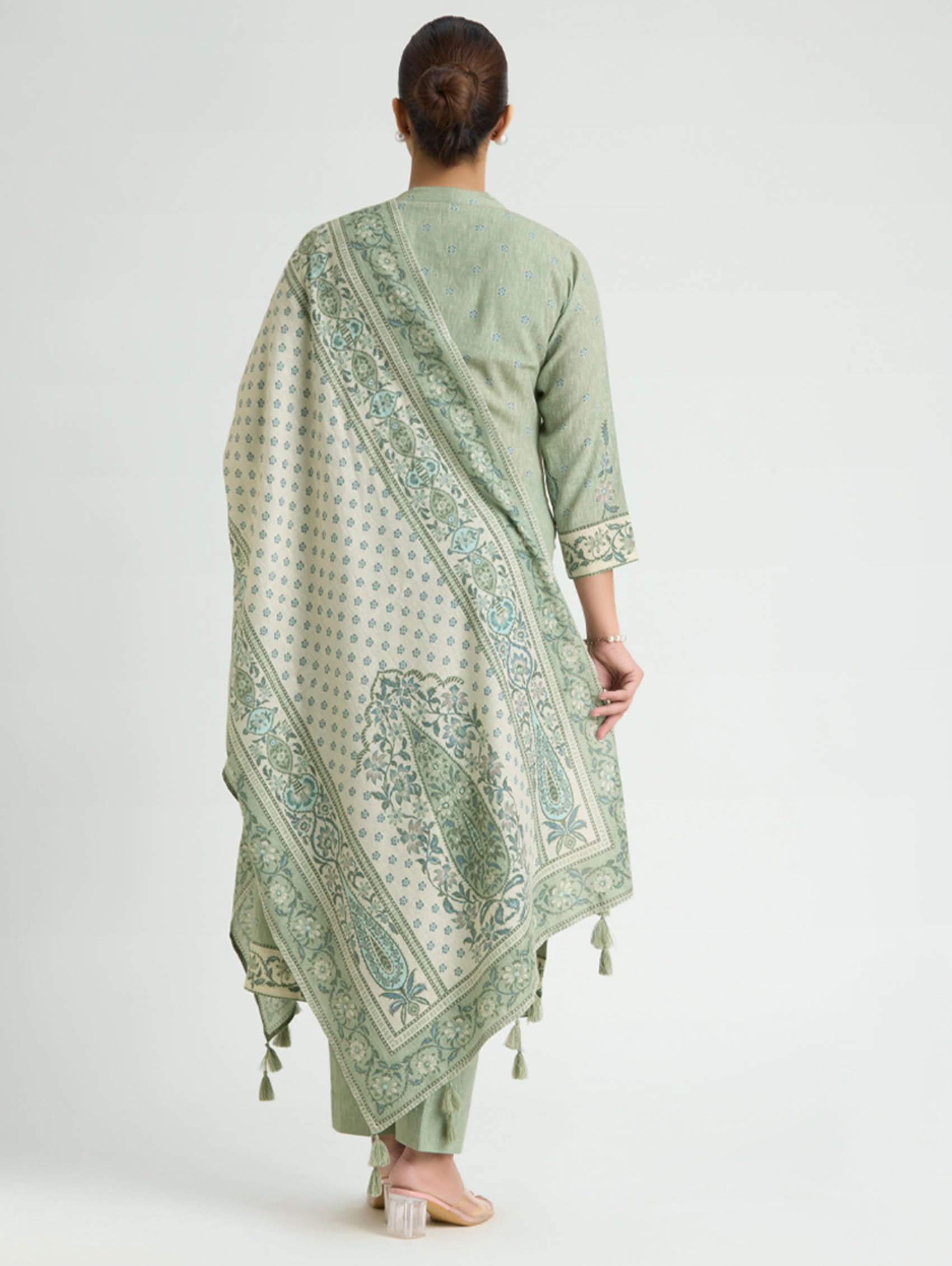 Woman wearing a light green traditional outfit with a matching dupatta on a white background