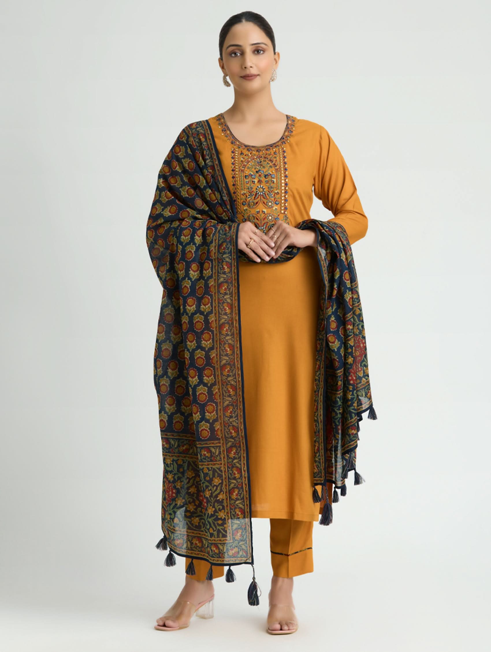 Woman wearing a mustard yellow kurta with a patterned dupatta on a white background