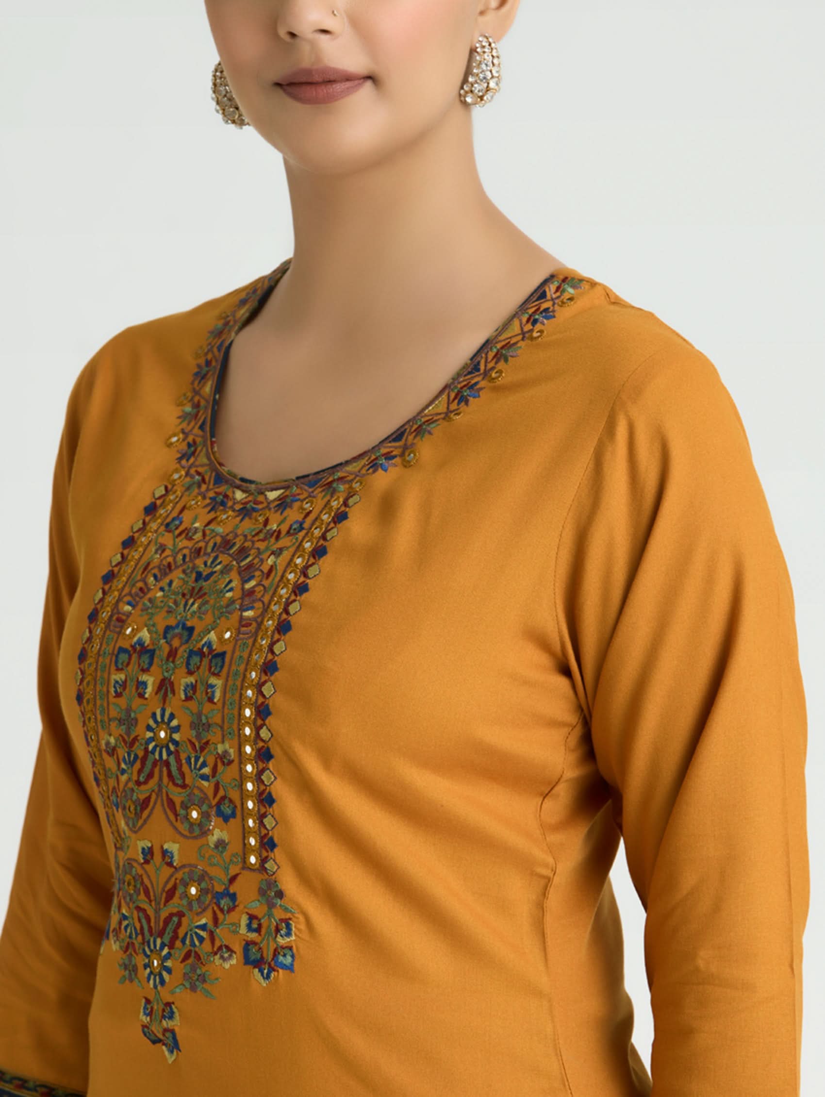 Mustard yellow long-sleeve top with intricate beadwork on a plain background
