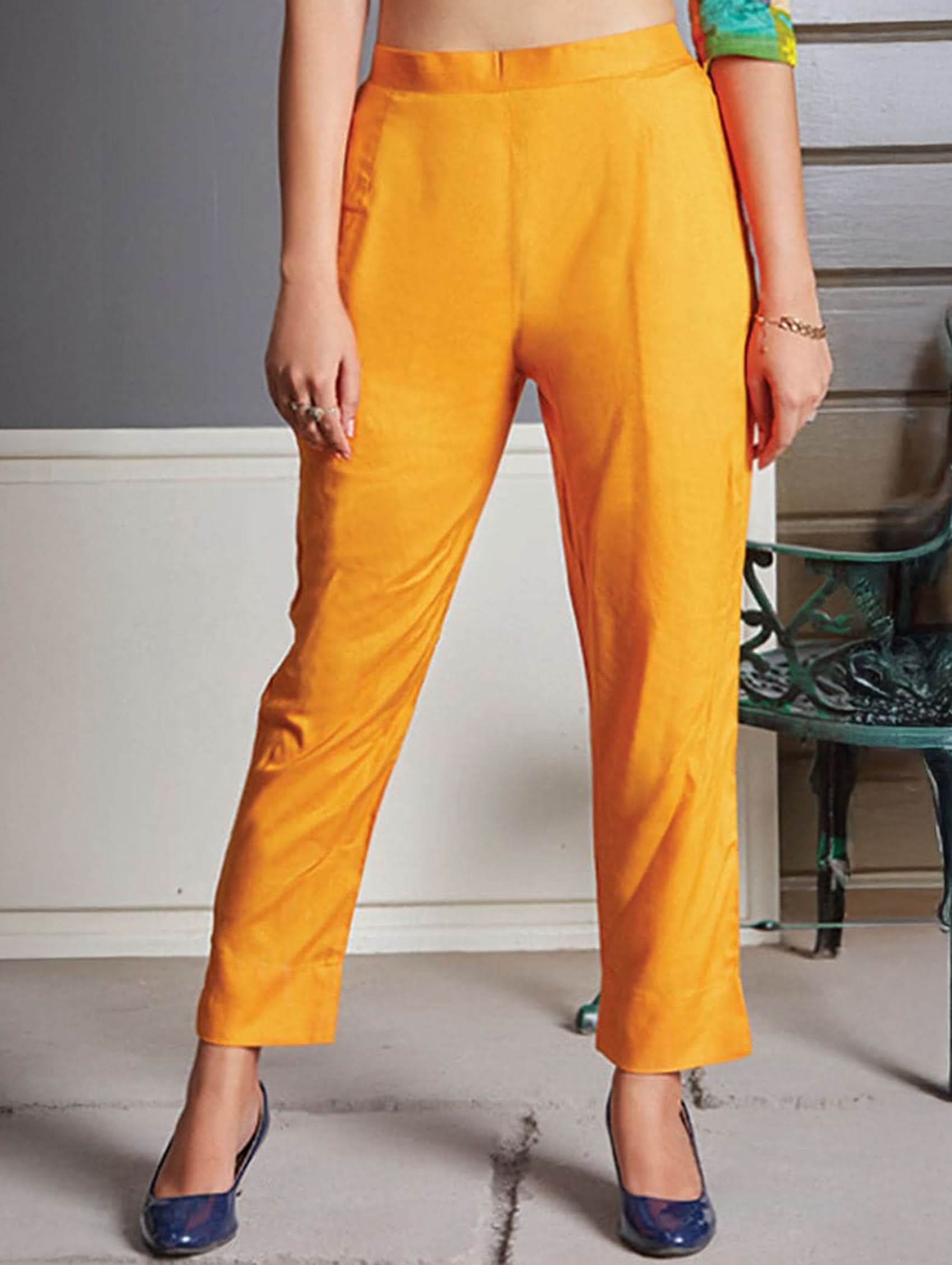 Person wearing bright Mustard pants with a neutral background