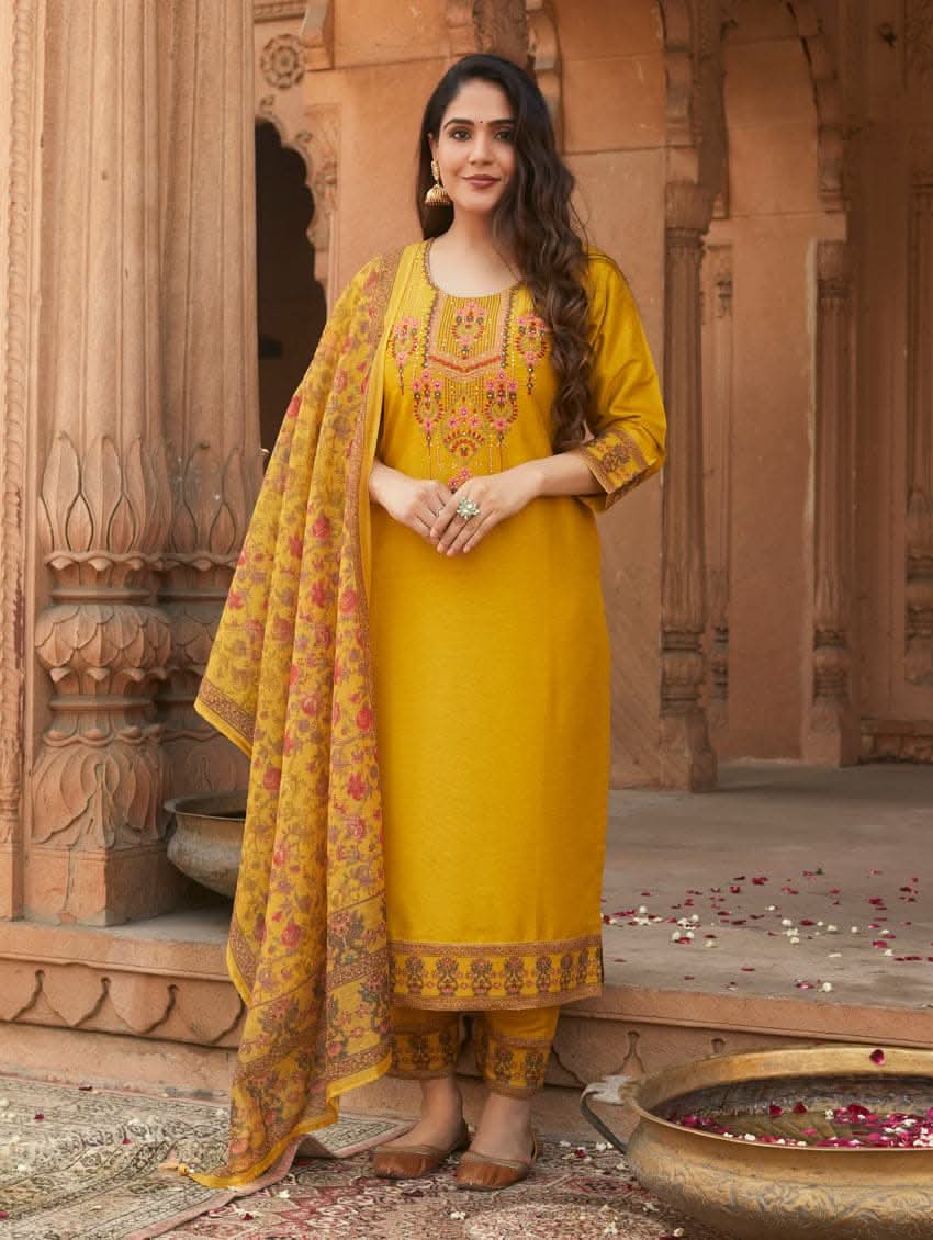 A woman wearing a yellow linen silk suit set with embroidery, consisting of a kurta, pants, and a dupatta.