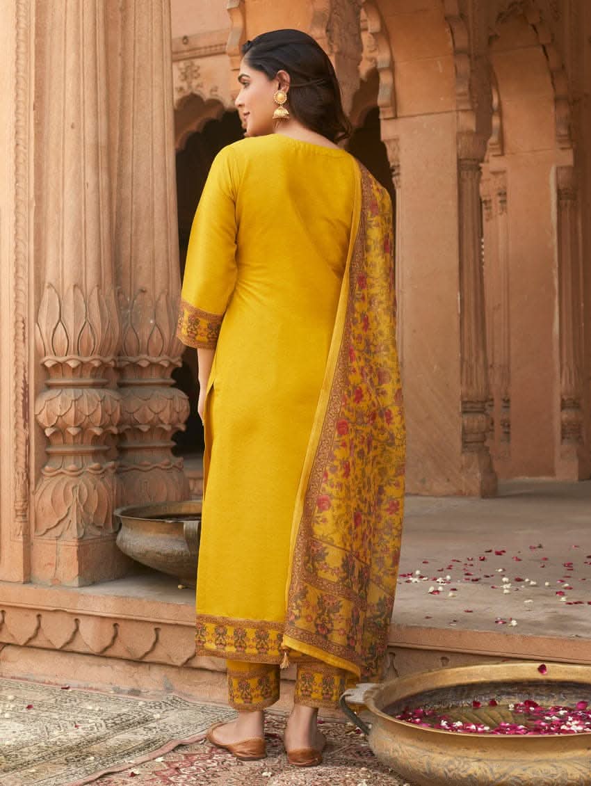 A woman wearing a yellow linen silk suit set with embroidery, consisting of a kurta, pants, and a dupatta.