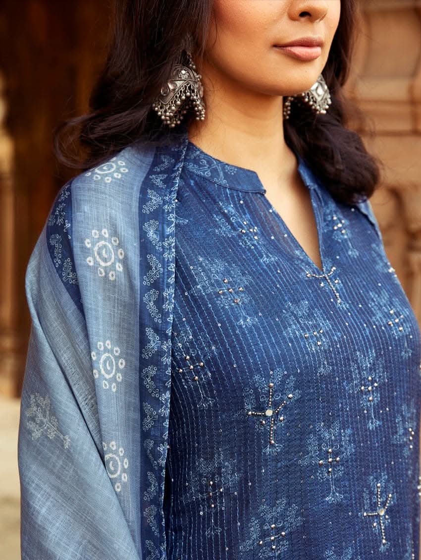 A woman wearing a traditional Digitally Printed Blue Silk Suit Set with a kurta, pants, and dupatta in a historic building with intricate architectural details.