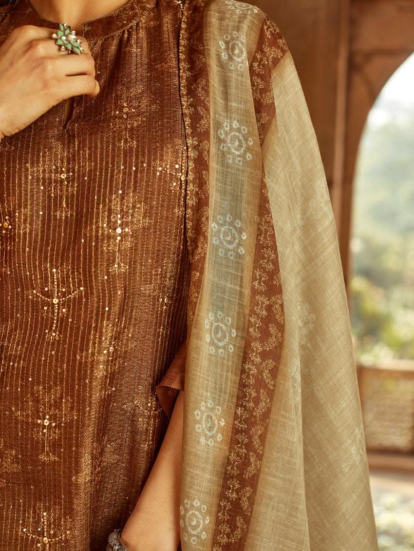 A woman wearing a traditional Digitally Printed Silk Suit Set with a kurta, pants, and dupatta in a historic building with intricate architectural details.
