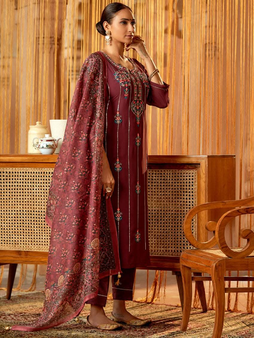 A woman standing in an elegant pose wearing a purple georgette suit with embroidered details and a dupatta with digital printed chanderi silk.