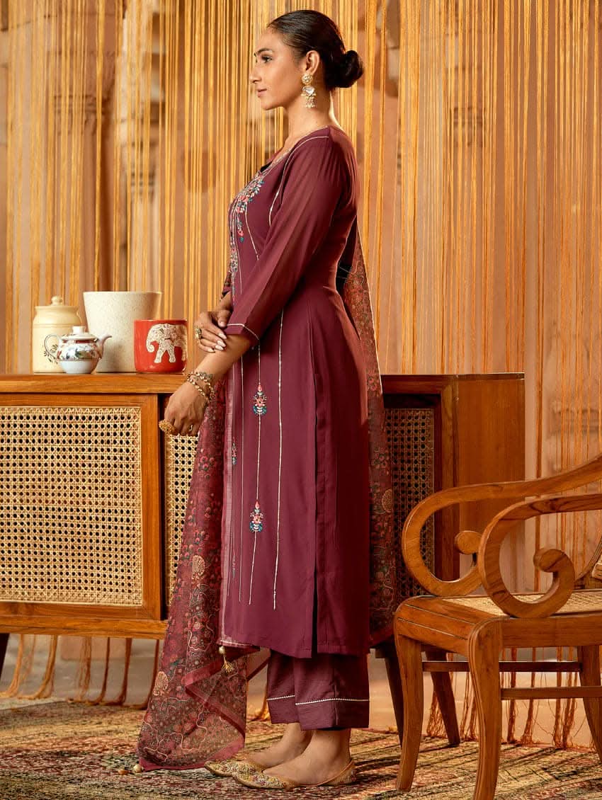 A woman standing in an elegant pose wearing a purple georgette suit with embroidered details and a dupatta with digital printed chanderi silk.