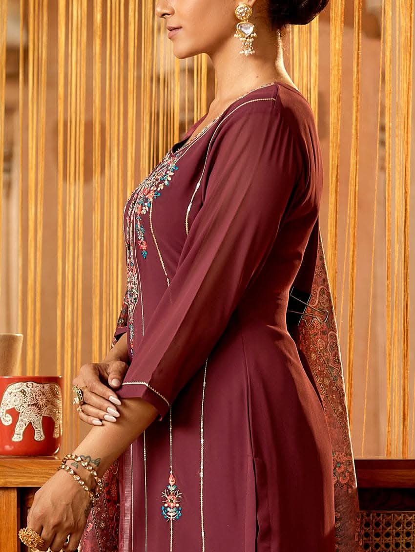 A woman standing in an elegant pose wearing a purple georgette suit with embroidered details and a dupatta with digital printed chanderi silk.