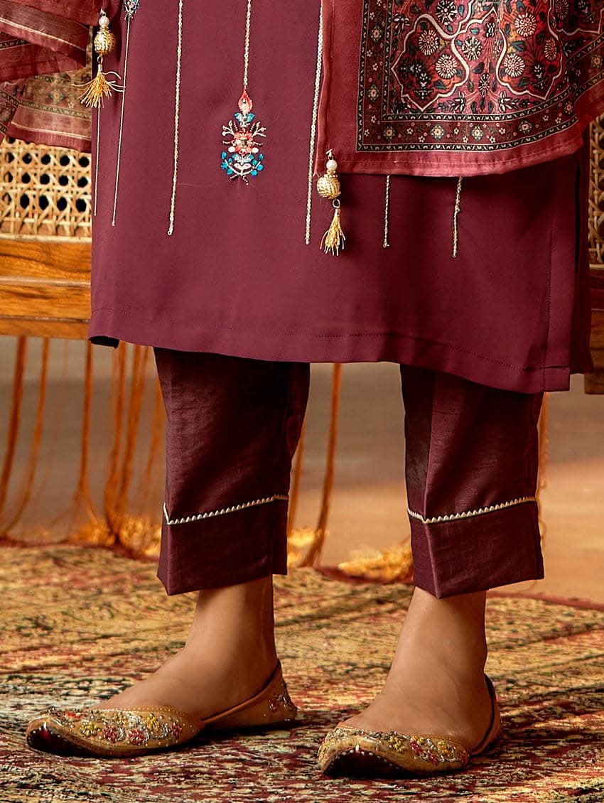A woman standing in an elegant pose wearing a purple georgette suit with embroidered details and a dupatta with digital printed chanderi silk.