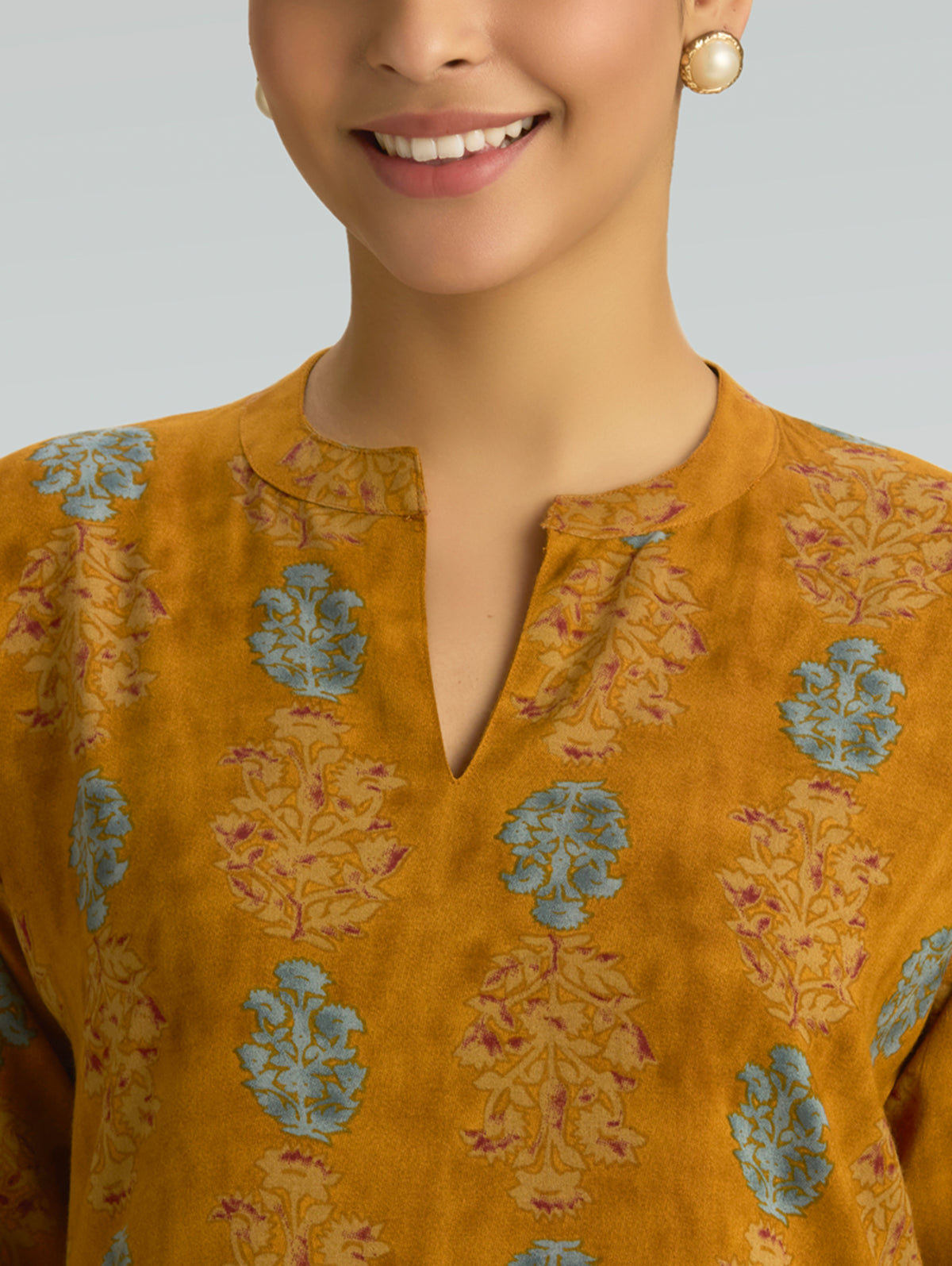 Mustard kurta with V-neck and blue floral block prints, front torso close-up