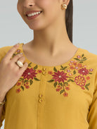 Yellow top with floral embroidery on a plain background
