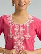 Pink top with white embroidery on a gray background
