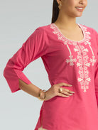 Pink kurta with white embroidery on a gray background