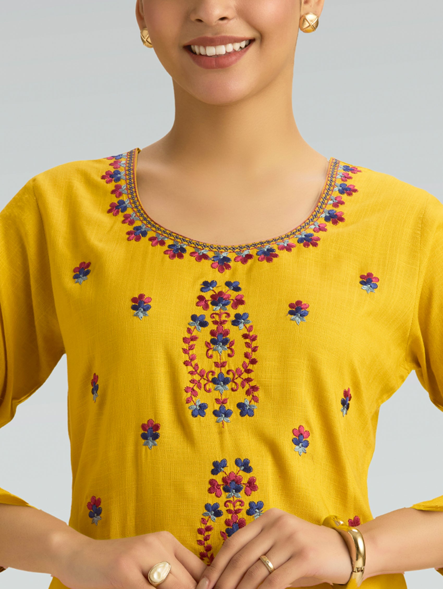 Yellow top with colorful embroidery on a gray background