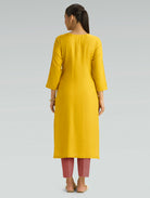 “A woman wearing a yellow kurta, shown from the back against a plain background.”