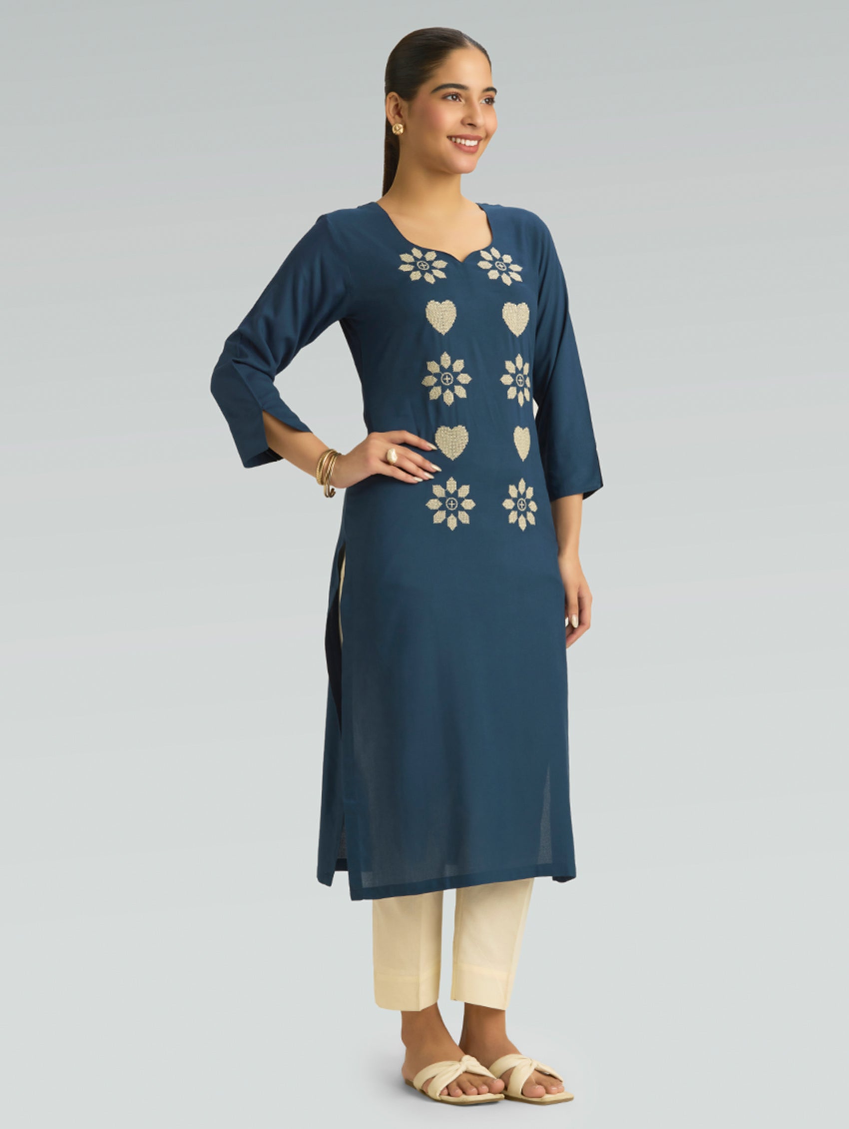 Woman wearing a blue kurta with floral patterns on a light gray background