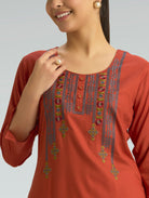 Red kurta with intricate embroidery on a plain background