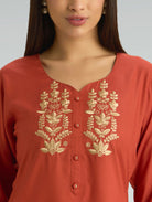Red kurta with gold embroidery on a plain background
