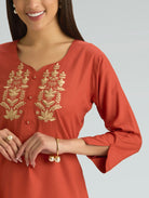 Red kurta with gold embroidery on a plain background