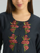 Navy blue top with floral embroidery on a plain background