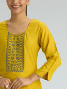 Yellow kurta with black floral embroidery on a gray background