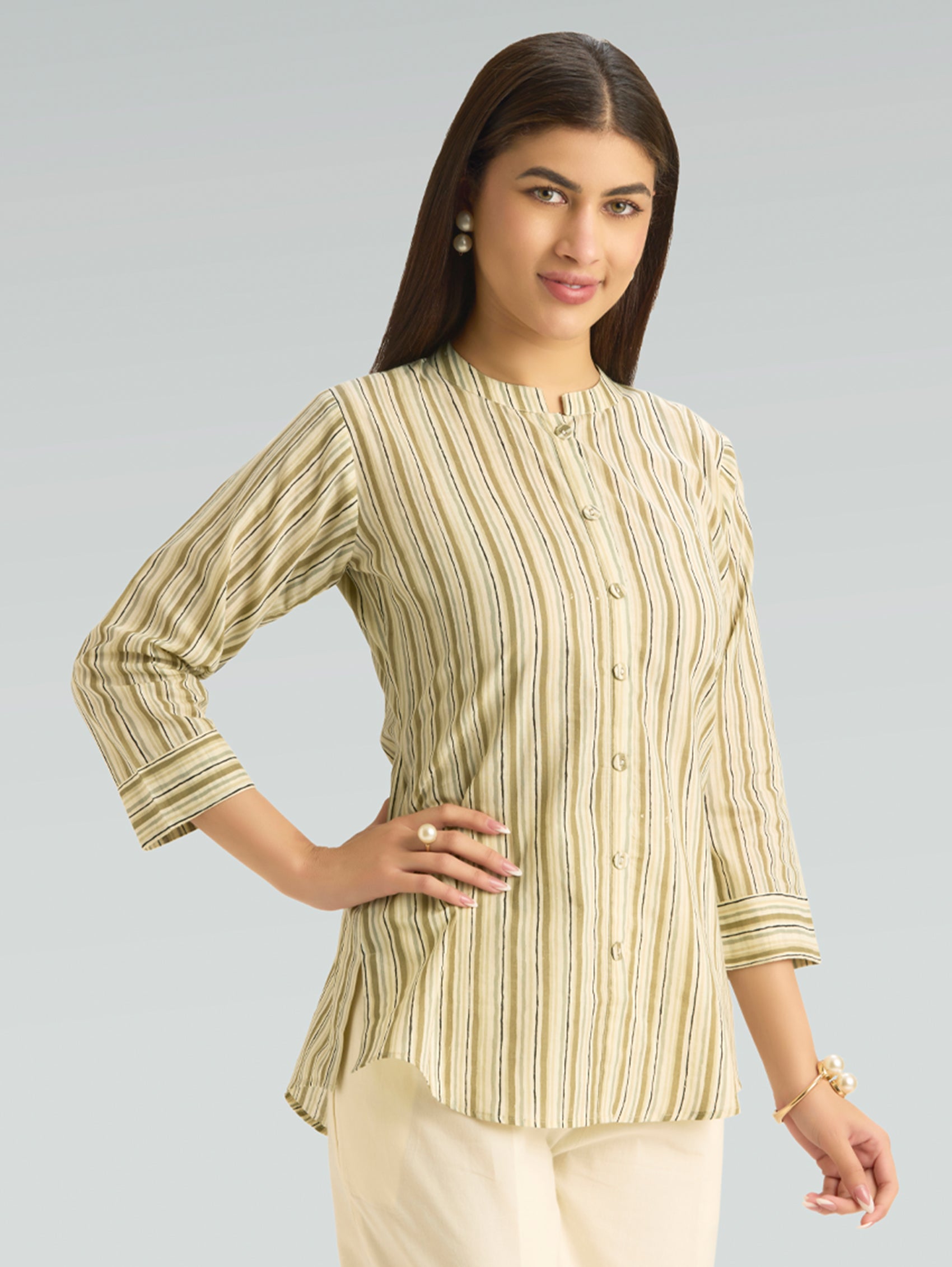 Woman wearing a green and white striped shirt against a gray background