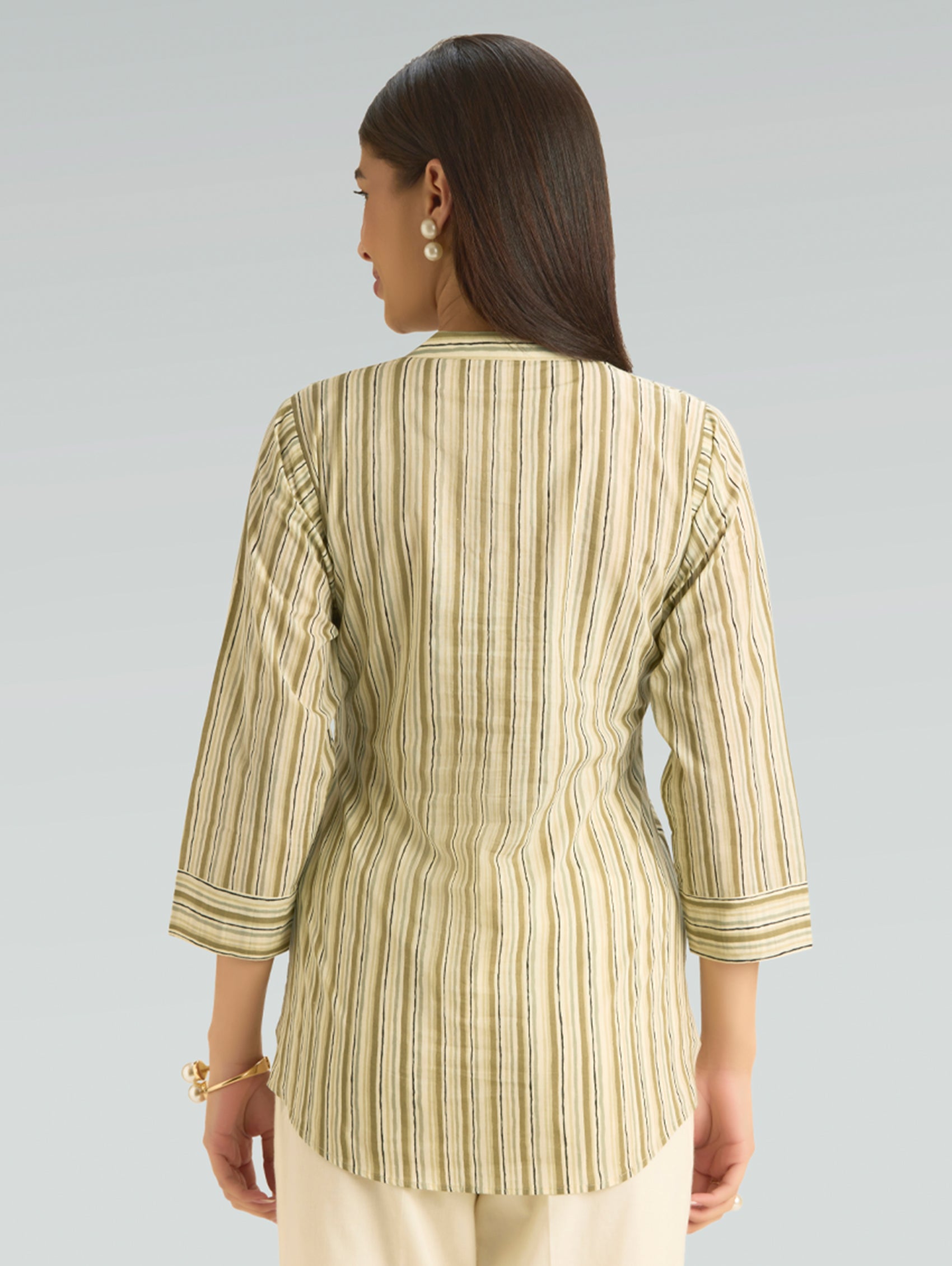 Woman wearing a striped shirt with a plain background