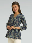 Woman wearing a patterned blouse against a plain background