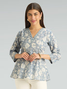 Woman wearing a floral blouse with a plain background