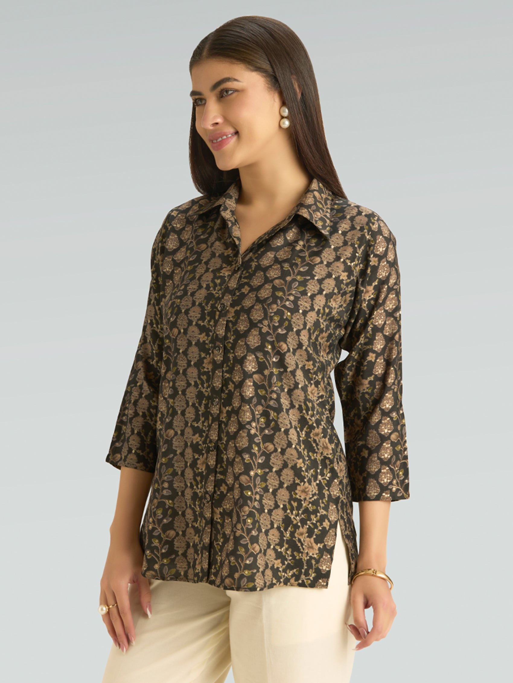 Woman wearing a patterned shirt against a plain background