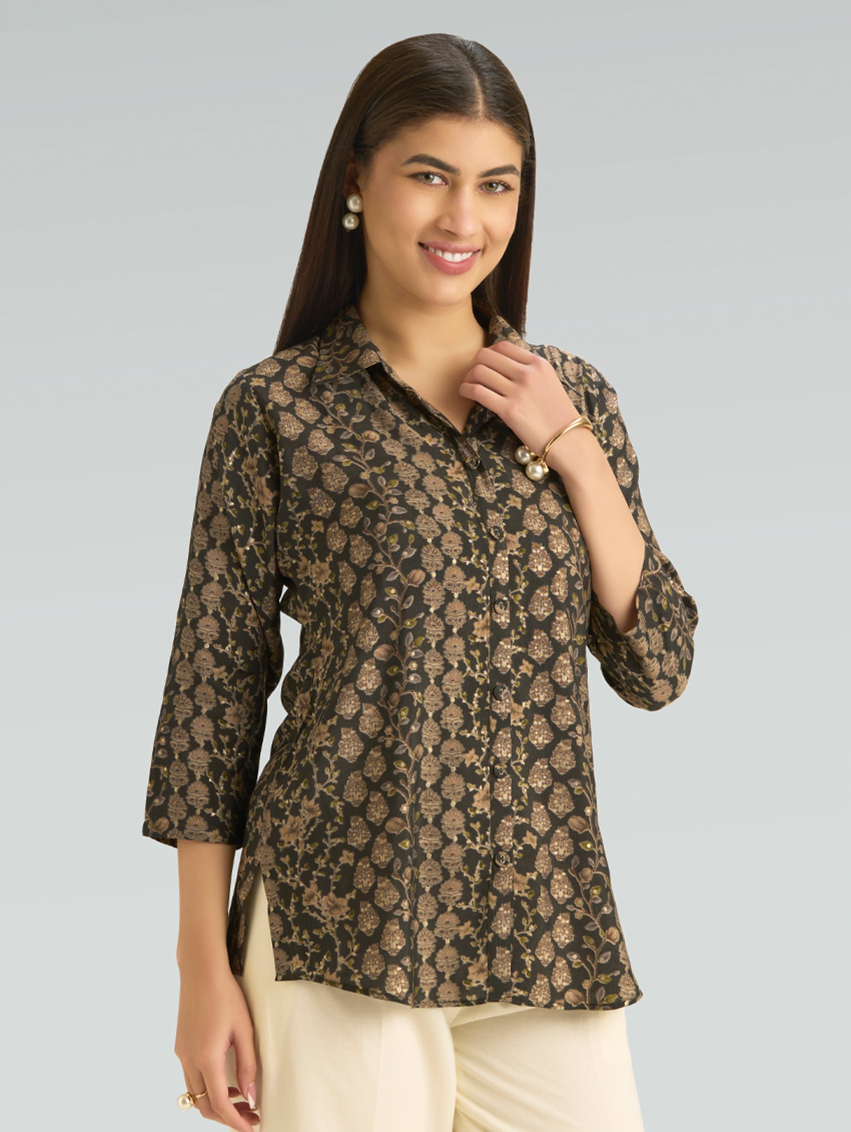 Woman wearing a patterned blouse against a plain background