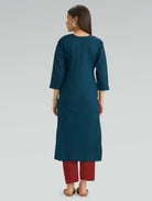 A woman in a teal kurta paired with red pants, shown in a back pose against a gray background.