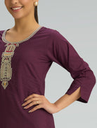 Purple dress with intricate beading on a plain background