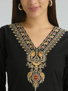 Black garment with intricate gold embroidery on a plain background