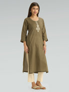 Woman wearing an olive green kurta with white embroidery on a gray background