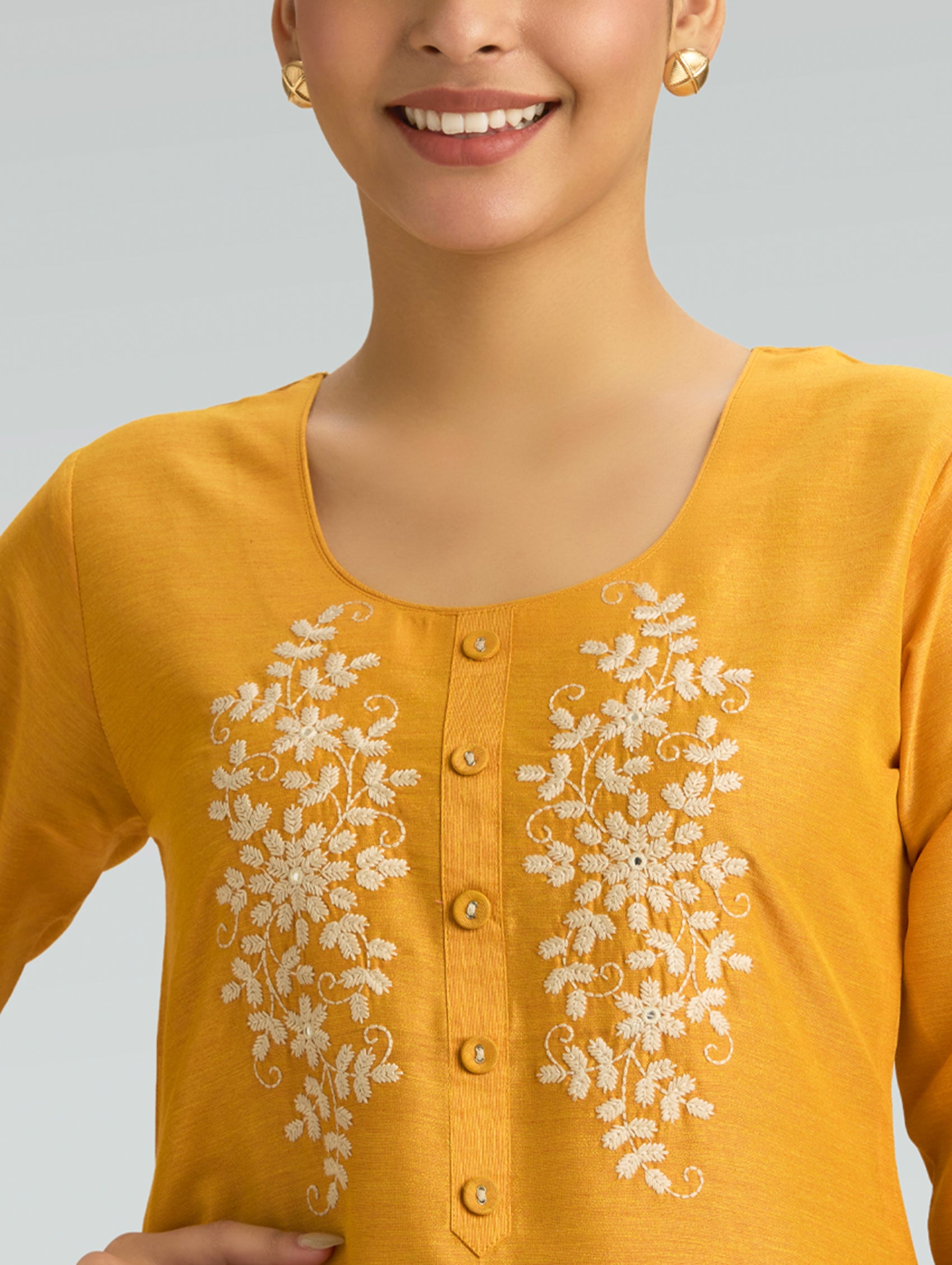 Yellow kurta with white floral embroidery on a plain background. with round nackline