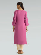 A woman is wearing a pink kurta for women, featuring a plain back design and a comfortable straight-fit silhouette.