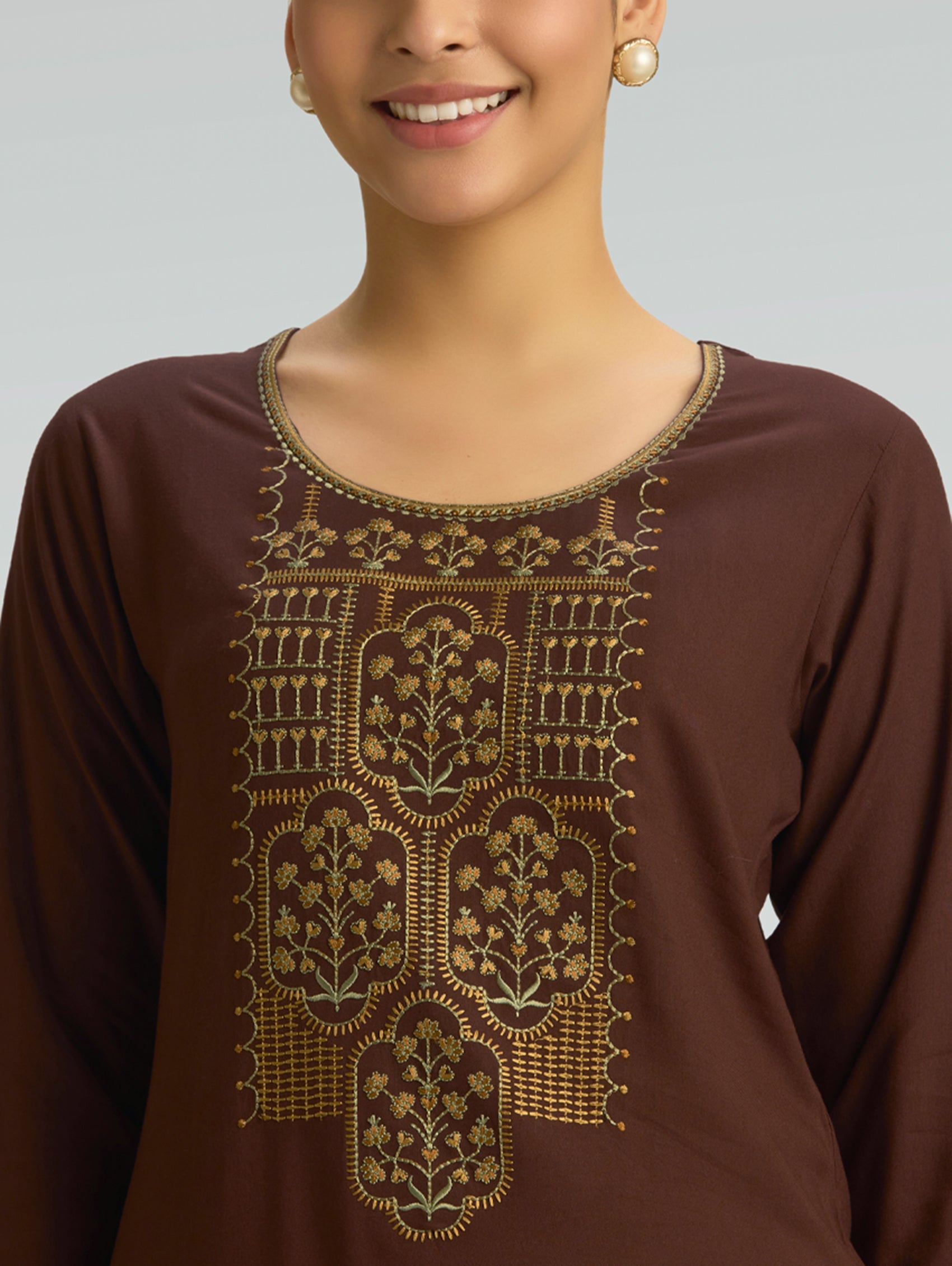A brown top featuring intricate gold embroidery on a solid background.