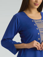 Blue top with intricate gold embroidery on a plain background