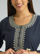 Navy blue top with intricate white embroidery on a gray background