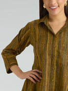 Woman wearing a brown striped shirt against a gray background