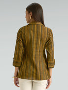 Woman wearing a striped brown shirt against a gray background