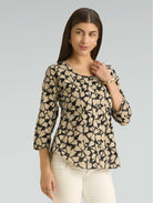 Woman wearing a patterned top with a plain background