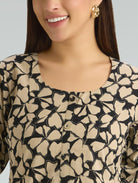 Close-up of a woman wearing a patterned top with a neutral background