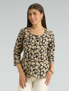 Woman wearing a patterned top with a plain background